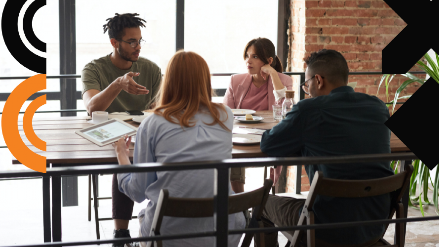 4 teammates discussing at a table in an office