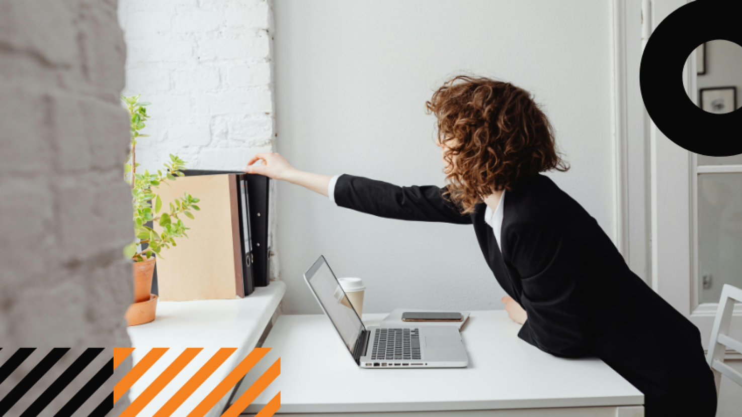 Woman in an office reaching for a folder