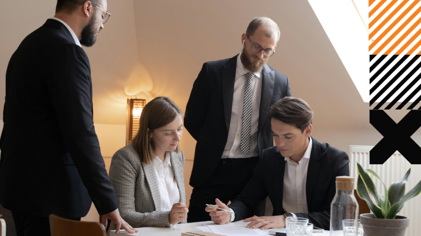 Four coworkers discussing around a desk