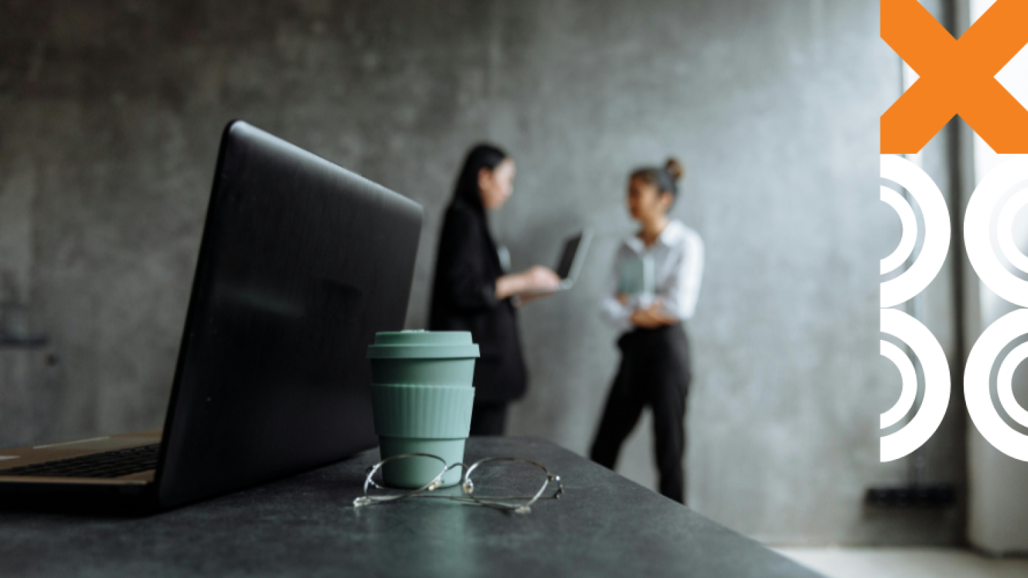 Work desk with coworkers discussing in the background